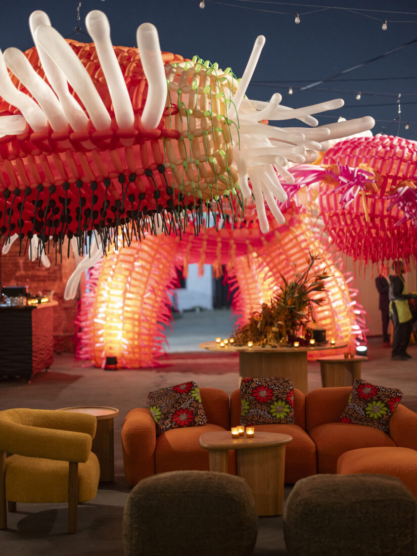 Tables at a party with large pink inflatables above them