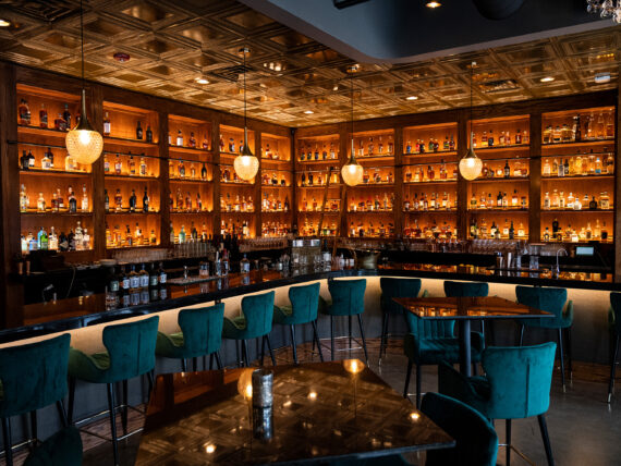 A view of a bar with bottles stacked on shelves