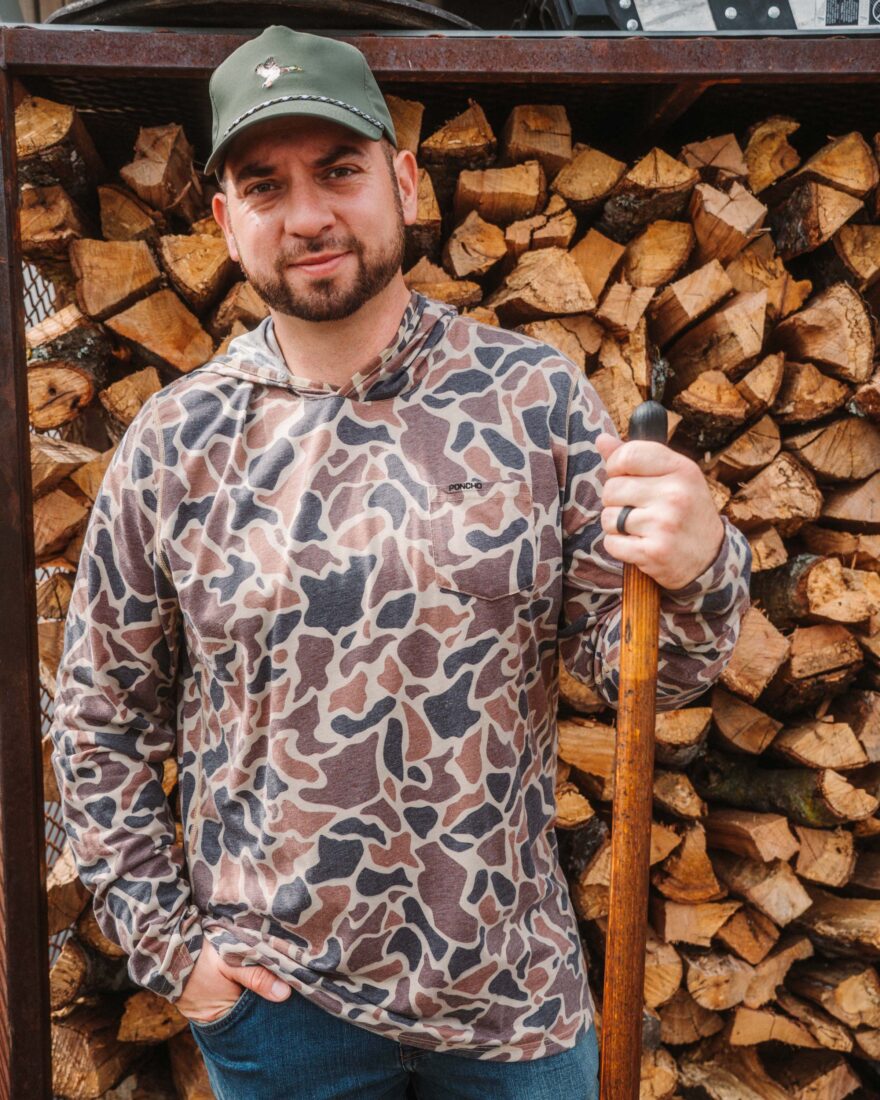 A portrait of a man in front of chopped wood