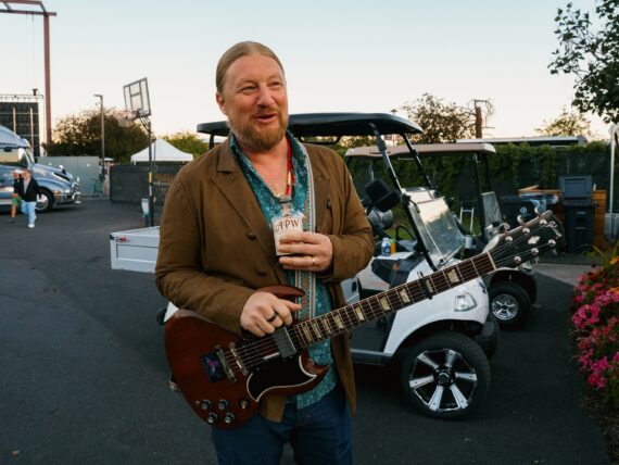 Derek Trucks holds a bottle of Ass Pocket Whiskey.