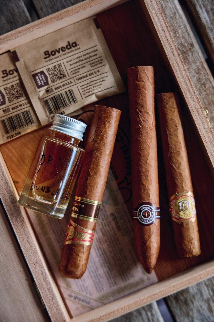 A tiny bottle of Scotch and cigars in a box