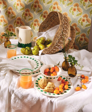 A spread of dinnerware plates and tomatoes on a table