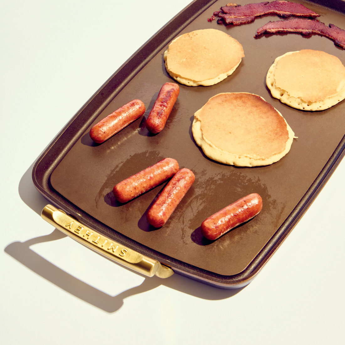 A griddle with pancakes and sausages