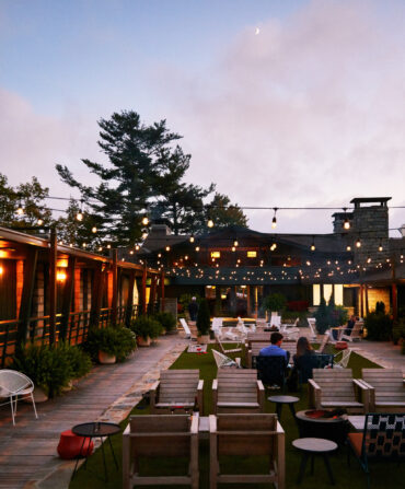 a couple sits on the Skyline Lodge patio at dusk