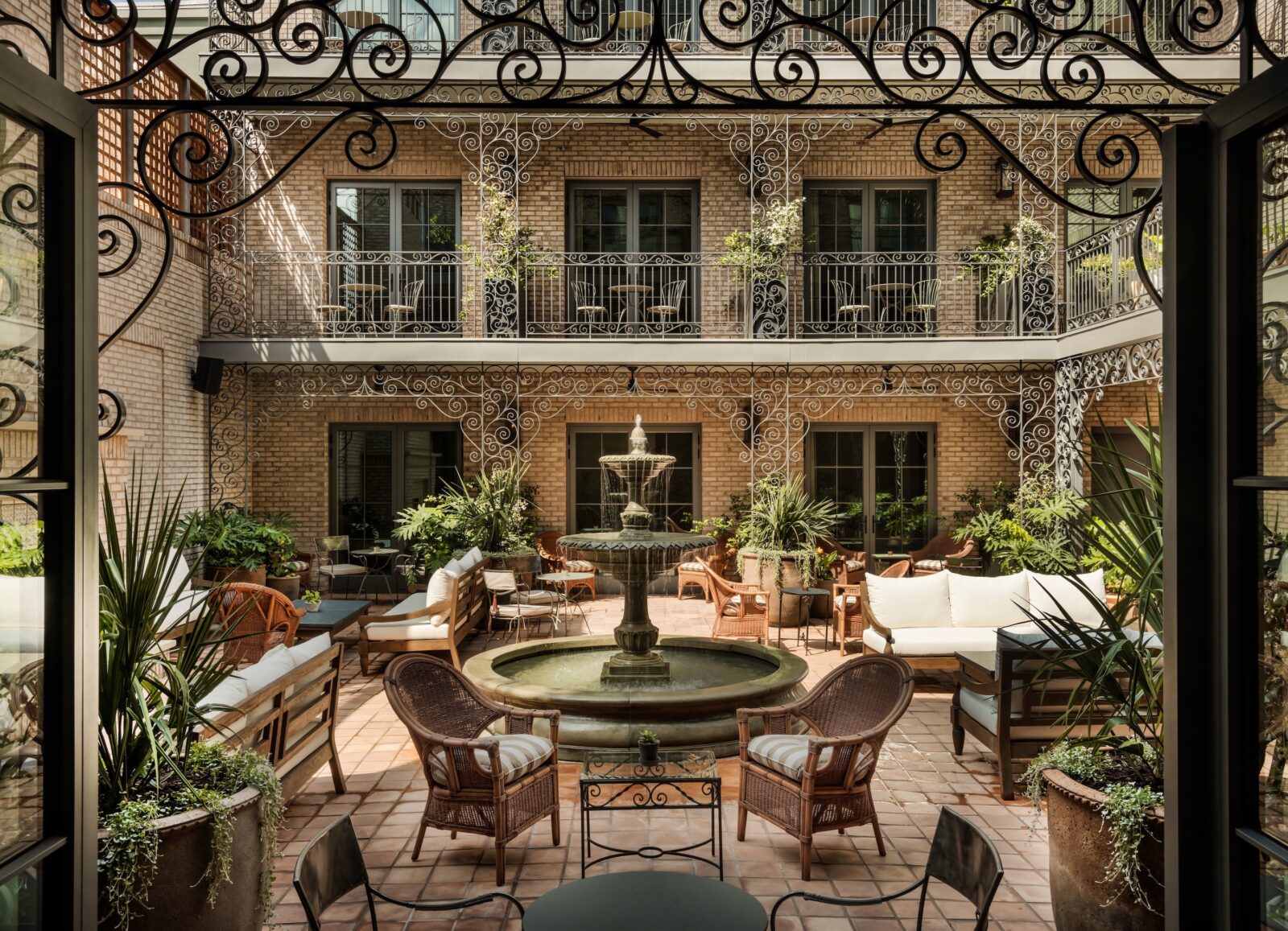 A courtyard with a fountain and elaborate ironwork