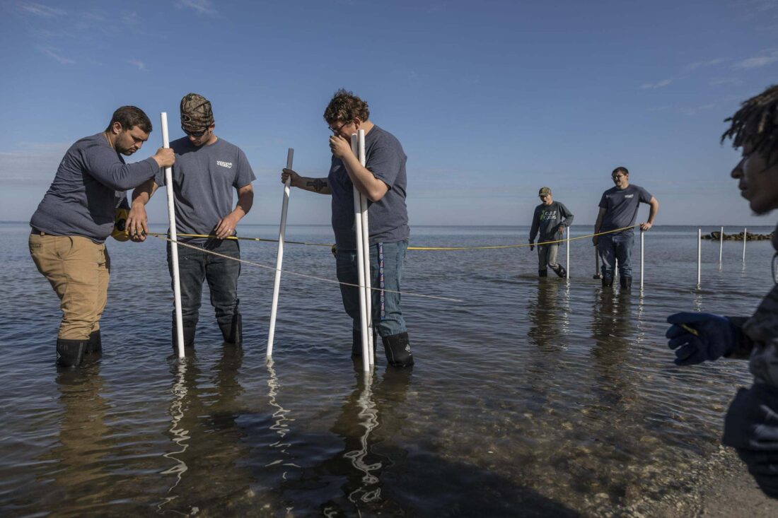 People stand in water with pipes