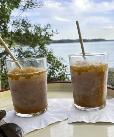 Bourbon slushes on a tray in front of a lake